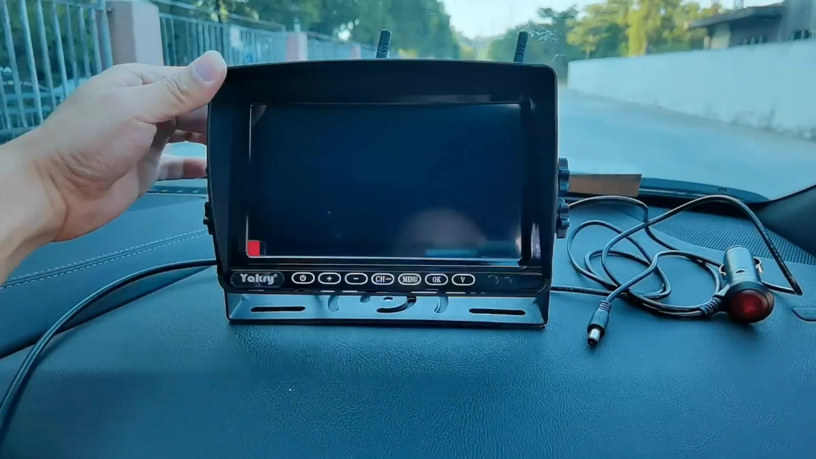 A seven-inch monitor held in front of a camper windscreen